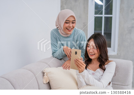 Joyful Friends Happy to Share a Special Moment Together on a Smartphone Device 130388416