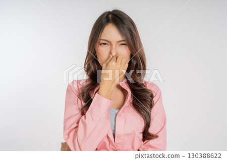 Woman Reacting Disgusting to an Unpleasant Odor with a Highly Disgusted Expression 130388622