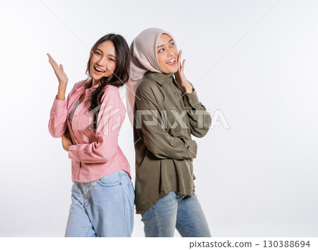 Two friends are posing playfully together in their stylish and casual attire Two friends are posing playfully together in their stylish and casual attire 130388694