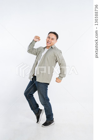 A lively and energetic young man is joyfully expressing his happiness in a studio setting A lively and energetic young man is joyfully expressing his happiness in a studio setting 130388736