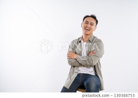 A Happy Young Man Sitting on a Stool Studio Portrait Full of Life and Joy 130388753