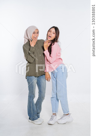 Two Young Women Joyfully Celebrating Their Friendship While Wearing Trendy Outfits 130388801