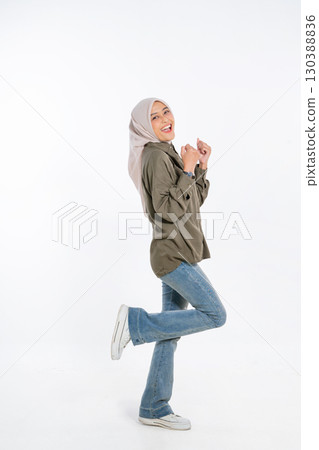A Joyful Young Woman Dressed in Casual Attire Positively Posing Cheerfully for the Camera 130388836