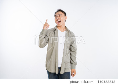 A young man is showing excitement while gesturing with a finger against a white background 130388838