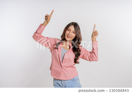 Joyful Young Woman Celebrating with Raised Hands Against a Clean White Background Joyful Young Woman Celebrating with Raised Hands Against a Clean White Background 130388843