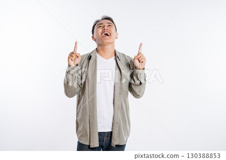 A Joyful Man Pointing Upwards in Excitement Against a Clean, Clear Background 130388853