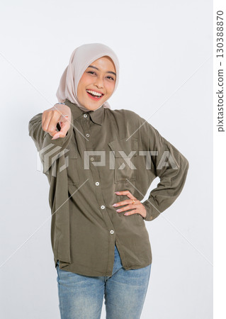 A Cheerful Young Woman in a Casual Outfit Pointing Enthusiastically at the Camera A Cheerful Young Woman in a Casual Outfit Pointing Enthusiastically at the Camera 130388870