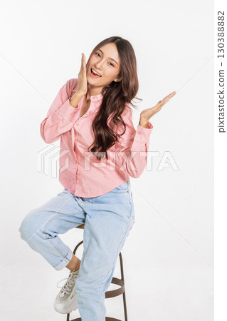 A Cheerful Young Woman is Posing Playfully with a Bright and Smiling Expression A Cheerful Young Woman is Posing Playfully with a Bright and Smiling Expression 130388882