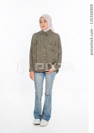 A Fashionable Woman Wearing a Casual Outfit and Hijab Poses on a White Background A Fashionable Woman Wearing a Casual Outfit and Hijab Poses on a White Background 130388909