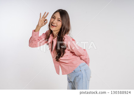 A Cheerful Young Woman Expressing a Gesture of Approval While Dressed Casually 130388924