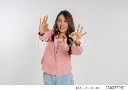 Joyful and Enthusiastic Young Woman Making Various Hand Gestures in a Studio Setting Joyful and Enthusiastic Young Woman Making Various Hand Gestures in a Studio Setting 130388961