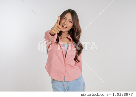 A Cheerful Young Woman Making a Fun Gesture Against a White Background, Radiating Joy 130388977