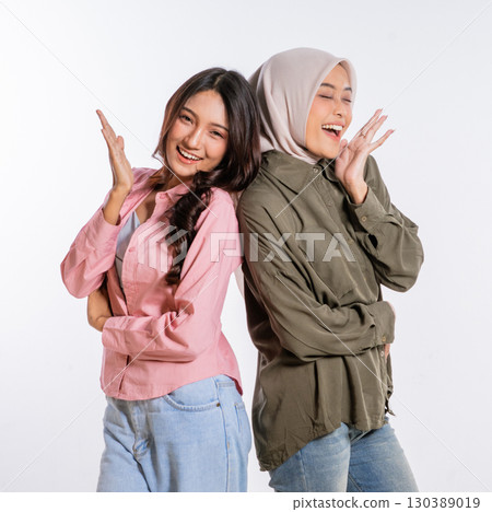 Joyful young women joyfully embracing their beautiful friendship in stylish outfits 130389019