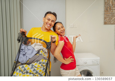 A Joyful and Happy Couple Celebrating Laundry Day at Home with Their Childs Stroller 130389037