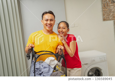 A Happy Couple Engaging in Laundry Activities Together in a Cozy Home Environment 130389045