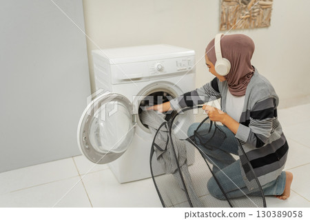 Handling Laundry with Care A Woman Operating the Washing Machine Efficiently 130389058