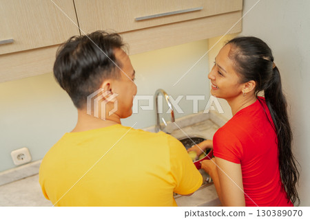 A Joyful Couple Cooking Together in a Beautifully Designed Modern Kitchen Space A Joyful Couple Cooking Together in a Beautifully Designed Modern Kitchen Space 130389070