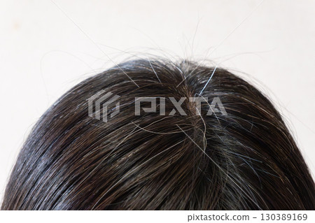 中年婦女頭頂的灰髮和散落頭髮的特寫圖像 130389169