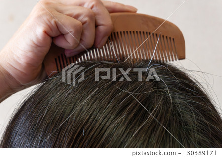 中年婦女頭頂的灰髮和散落頭髮的特寫圖像 130389171