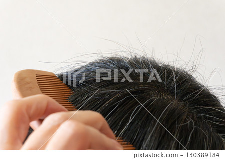 中年婦女頭頂的灰髮和散落頭髮的特寫圖像 130389184