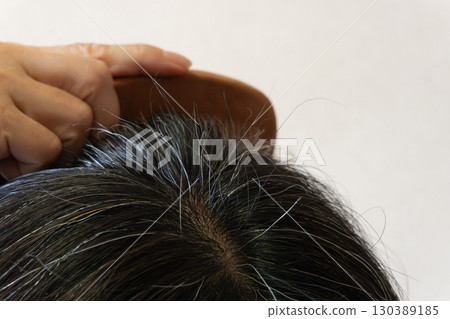 中年婦女頭頂的灰髮和散落頭髮的特寫圖像 130389185