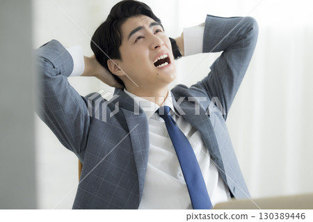 Businessman holding his head 130389446