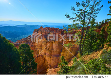 Bryce Canyon Hoodoos Pine Trees and Distant Mountains under Bright Blue Sky Bryce Canyon Hoodoos Pine Trees and Distant Mountains under Bright Blue Sky 130389746