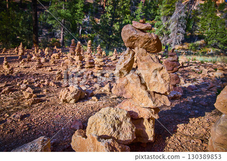Rock Cairns in Sunlight Among Pines and Red Earth in Utah Wilderness Rock Cairns in Sunlight Among Pines and Red Earth in Utah Wilderness 130389853