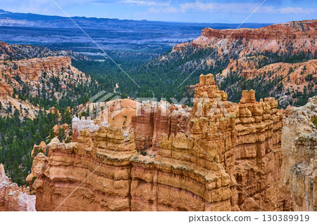 Bryce Canyon Hoodoo Formations Pine Forest and Distant Mesas Under Blue Sky 130389919