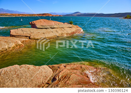 Red Sandstone Shoreline and Turquoise Lake Water Motion at Eye Level Perspective 130390124
