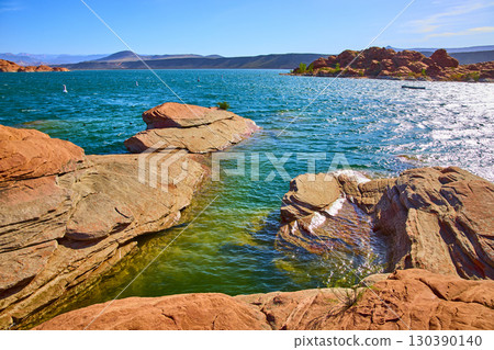 Red Sandstone and Blue Lake Water with Distant Hills Low Angle Lake Edge Red Sandstone and Blue Lake Water with Distant Hills Low Angle Lake Edge 130390140