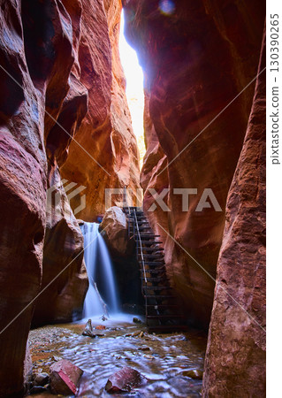 Waterfall Motion Red Sandstone Walls Metal Ladder in Slot Canyon Upward View Waterfall Motion Red Sandstone Walls Metal Ladder in Slot Canyon Upward View 130390265
