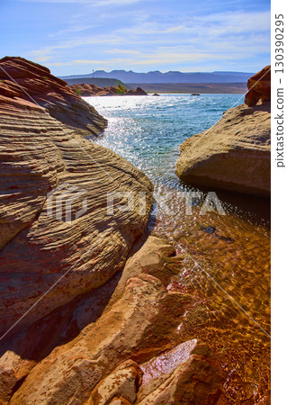 Layered Sandstone Shoreline and Clear Blue Water at Sand Hollow Lake Low Angle Layered Sandstone Shoreline and Clear Blue Water at Sand Hollow Lake Low Angle 130390295