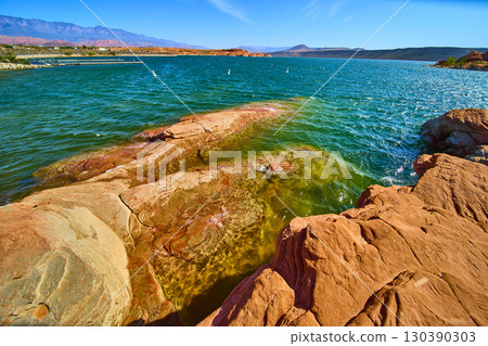 Red Sandstone Rocks and Turquoise Lake with Mountains at Sand Hollow Eye Level Red Sandstone Rocks and Turquoise Lake with Mountains at Sand Hollow Eye Level 130390303