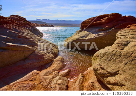 Red Sandstone Formations and Blue Lake Inlet with Distant Mesas Eye Level View 130390333
