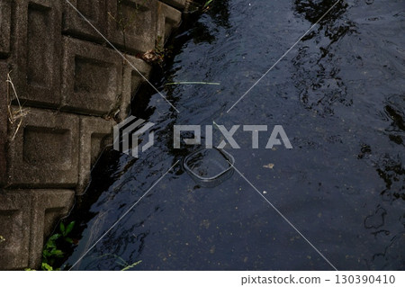 Plastic waste flowing into the river and a symbol of environmental issues 130390410