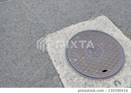Sewer manhole covers and pavement on roads Sewer manhole covers and pavement on roads 130390416