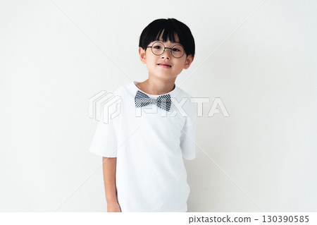 站在白牆前的小學男孩 130390585