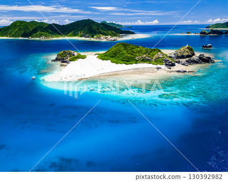 無人機拍攝的卡比島。遊客們在白色沙灘上。遮陽傘、船隻和薩巴尼船停泊在那裡。 130392982