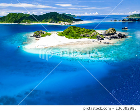 無人機拍攝的卡比島。遊客們在白色沙灘上。遮陽傘、船隻和薩巴尼船停泊在那裡。 130392983