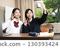 Female students taking selfies with their smartphones in the classroom 130393424