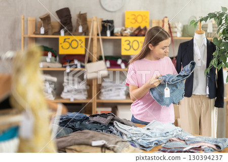 Search and selection of new jeans or shorts in a clothing store for young girl Search and selection of new jeans or shorts in a clothing store for young girl 130394237