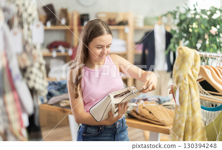 Teenager choosing a handbag in a store 130394248