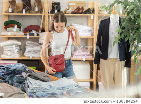 Teenage girl choosing handbag in store 130394254