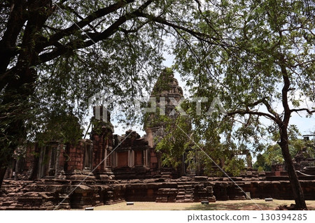 Scenery of Phimai Historical Park with the sky and ruins beyond the green leaves of the trees Scenery of Phimai Historical Park with the sky and ruins beyond the green leaves of the trees 130394285