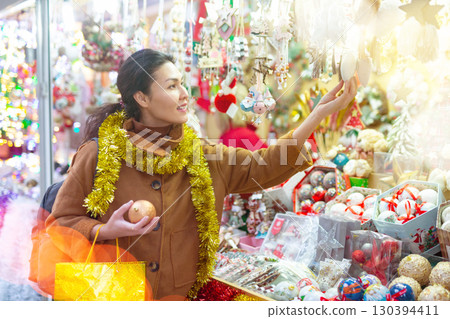 Female in tinsel on Christmas fair decoration on holiday 130394411