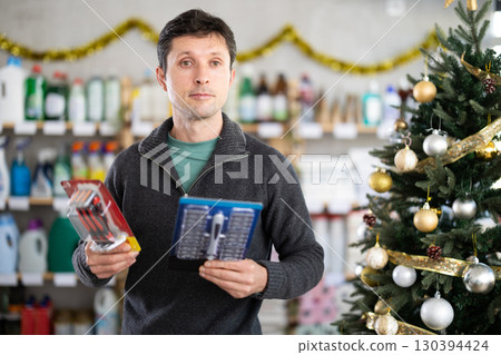 Adult man choosing razor in decorated store 130394424