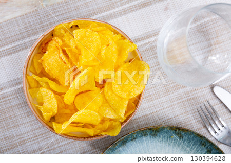 Crispy potato chips in cup on table Crispy potato chips in cup on table 130394628
