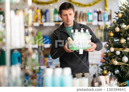 Adult man buyer chooses cosmetics gift set for christmas Adult man buyer chooses cosmetics gift set for christmas 130394641