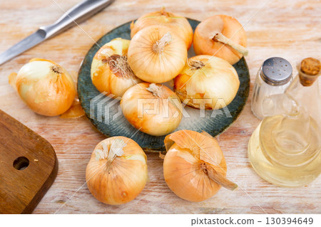 Yellow onion on kitchen table, food preparation 130394649